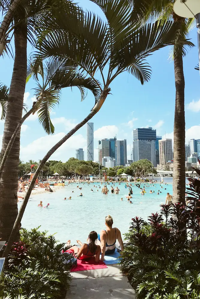 South Bank lagoon in Brisbane with people relaxing and city skyline in the background