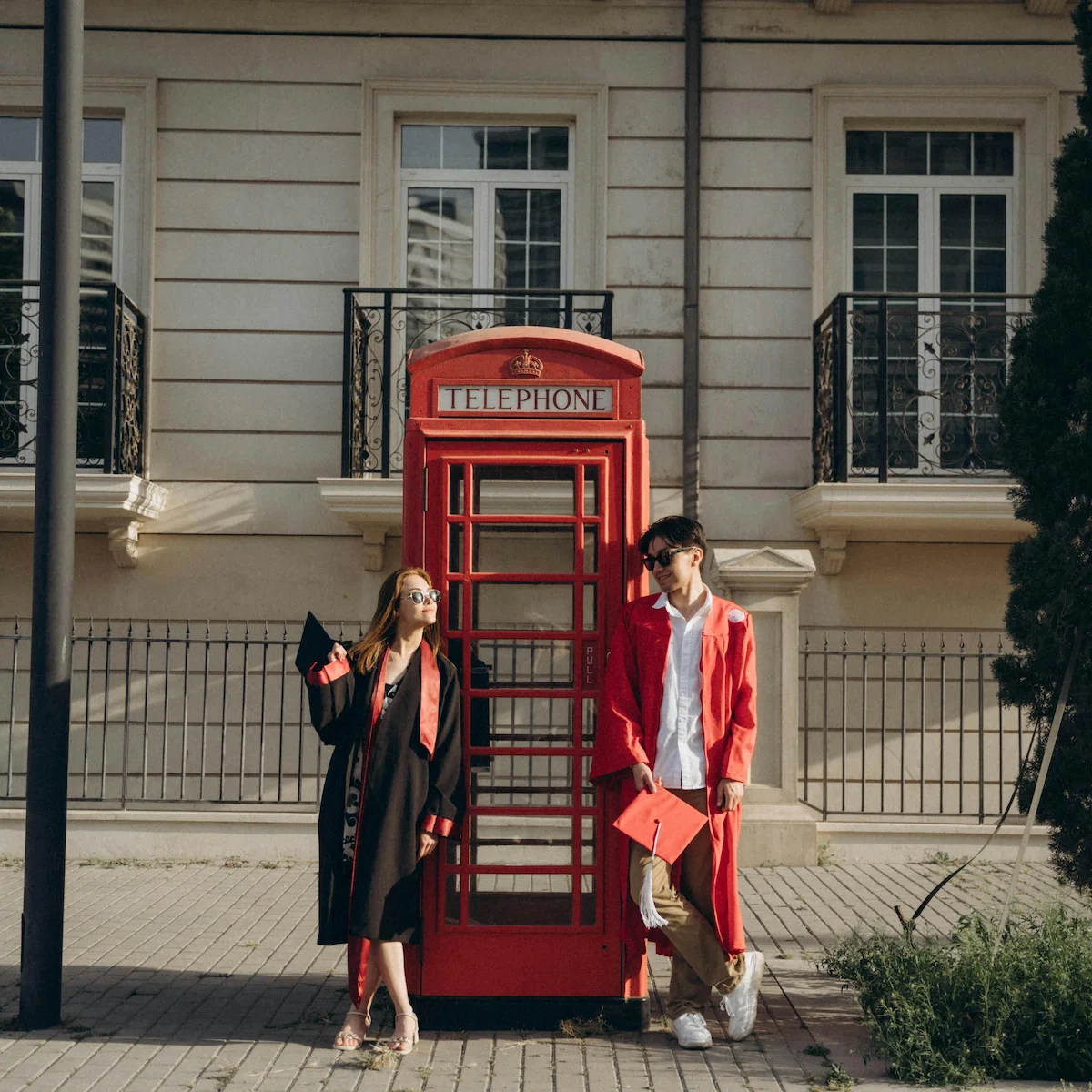 Graduating students posing in a telephone booth in London
