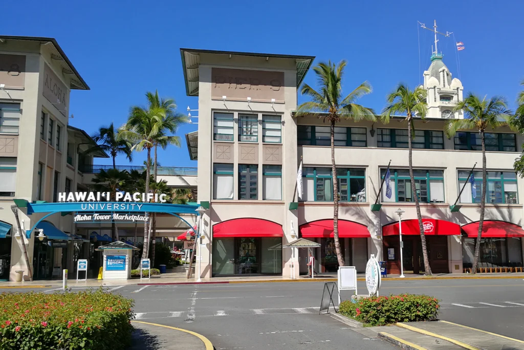 Entrance of Hawaii Pacific University near Aloha Tower in Honolulu with palm trees.