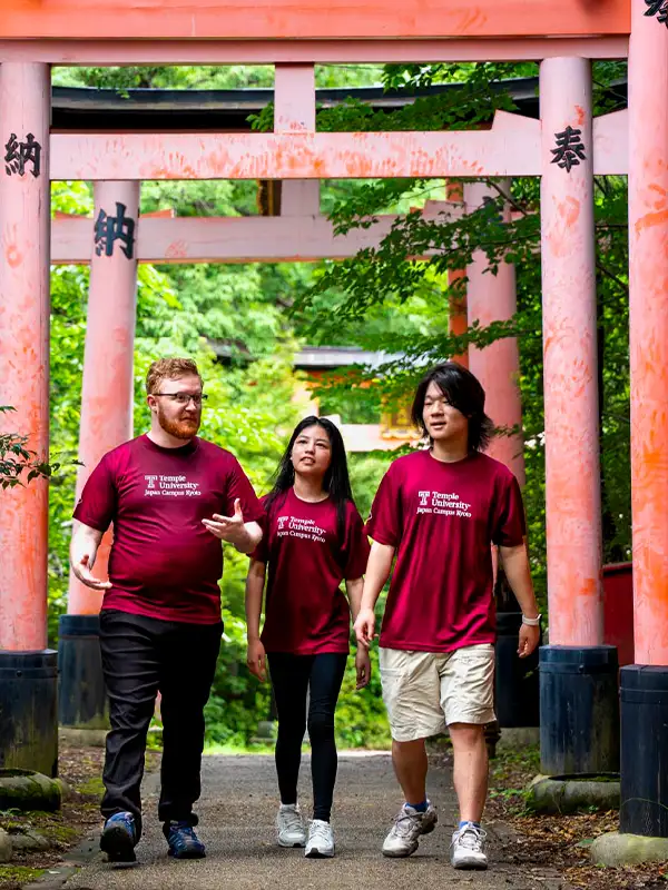 Temple University Japan students walking under traditional torii gates.