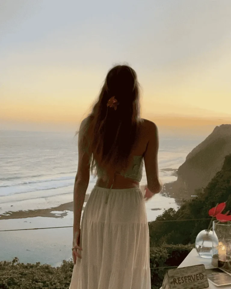 Exchange student alone in front of the sea at sunset