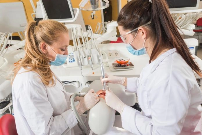 Two students at RSU practicing dentistry