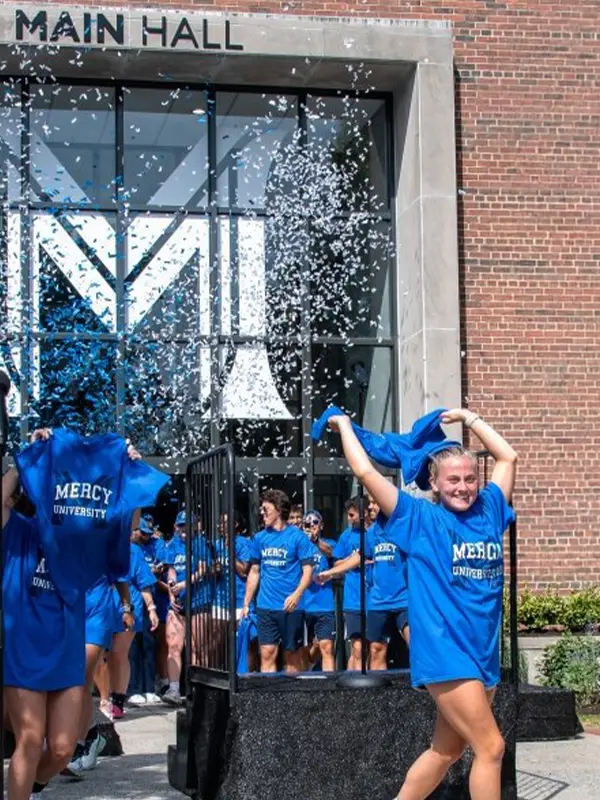 Students celebrating outside Main Hall at Mercy University in New York.