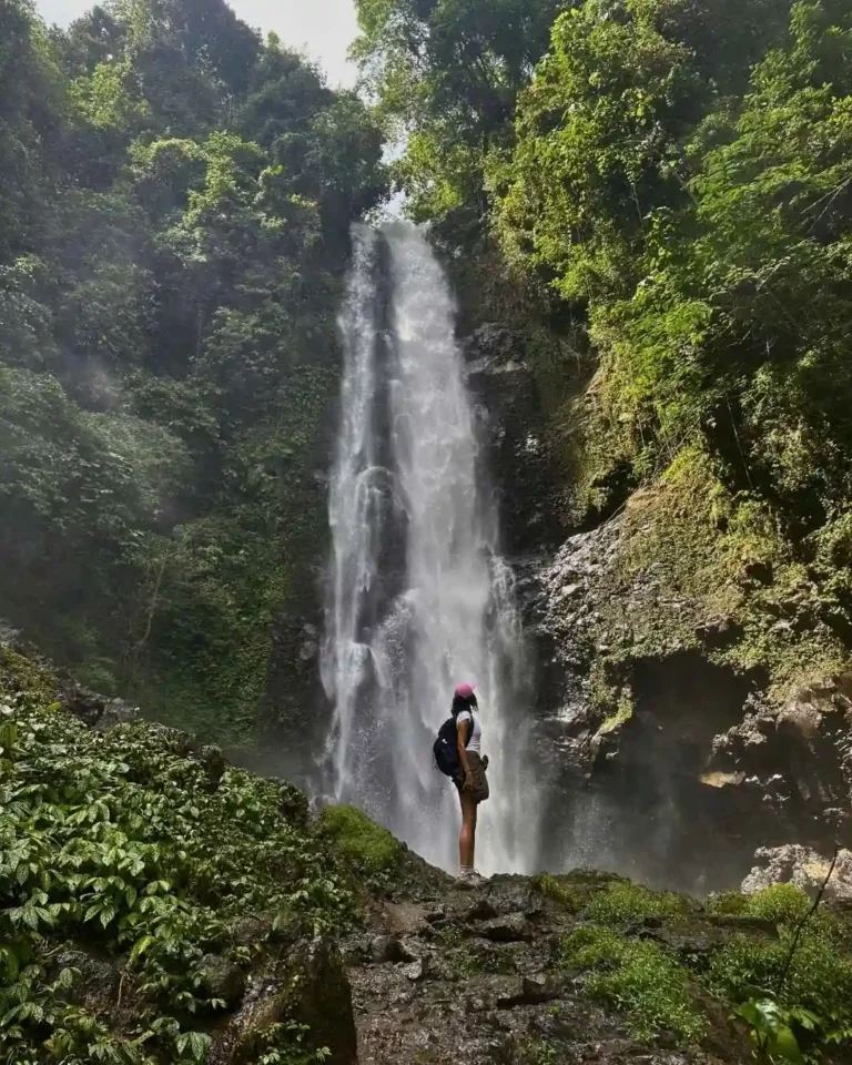Exchange student in Bali standing in front of a waterfall