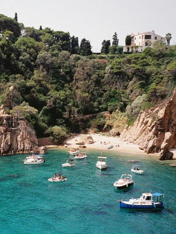 Turquoise bay with boats and hidden beach in Costa Brava, Spain, popular destination for international students