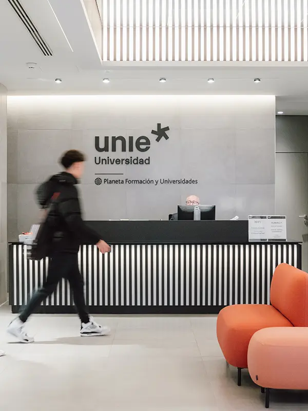 Interior reception area at UNIE Universidad in Madrid with modern design and student walking by